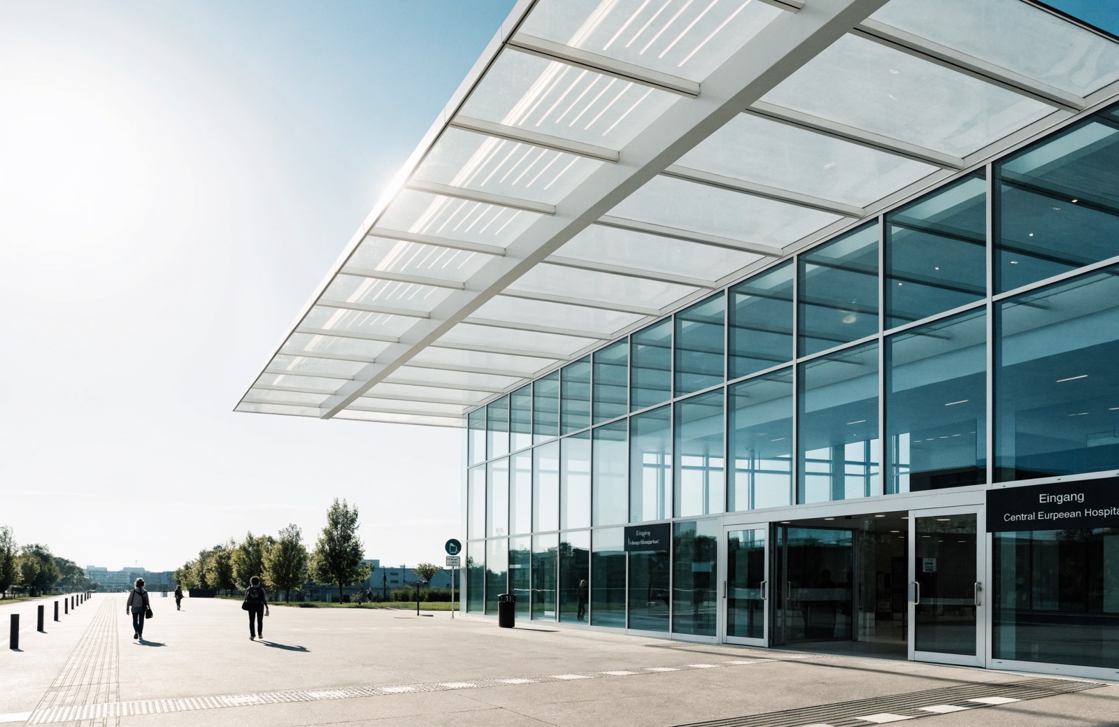 Pflegekraft auf dem Weg zum Dienst, Blick aus einem Klinikgang nach draussen